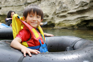 Little boy tubing down the river
