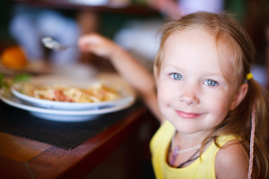 Little girl having lunch at a restaurant.