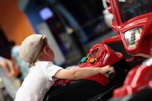 Young kid playing at an arcade.